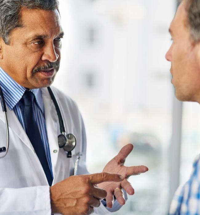 A male doctor speaking to a male patient.