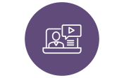 A purple circle with a white outline icon of a person in front of a computer screen. The screen shows a play button and lines representing text.