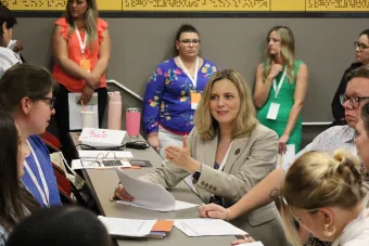 A group of women sitting around a desk talking during the 2024 Health Communication Leadership Institute