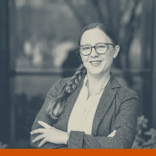 Headshot of Catherine Cunningham, CHC Program Manager and 2025 Health Communication Leadership Institute speaker. A white woman with long brown hair in a braid over one shoulder wearing a white blouse, gray blazer, and glasses smiling at the camera.